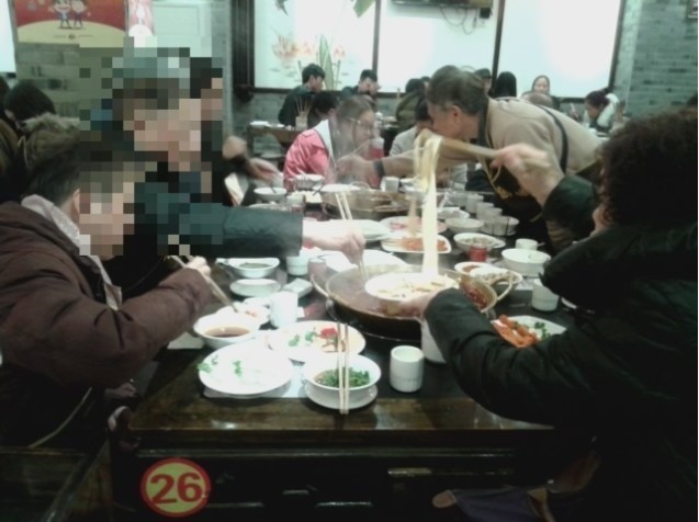 A family banquet in a modern city of central China. We can see the steam or water vapor that came from the pot and could spread the droplets (The face blurring is to protect the eaters. The picture was taken by Changhua Zou).